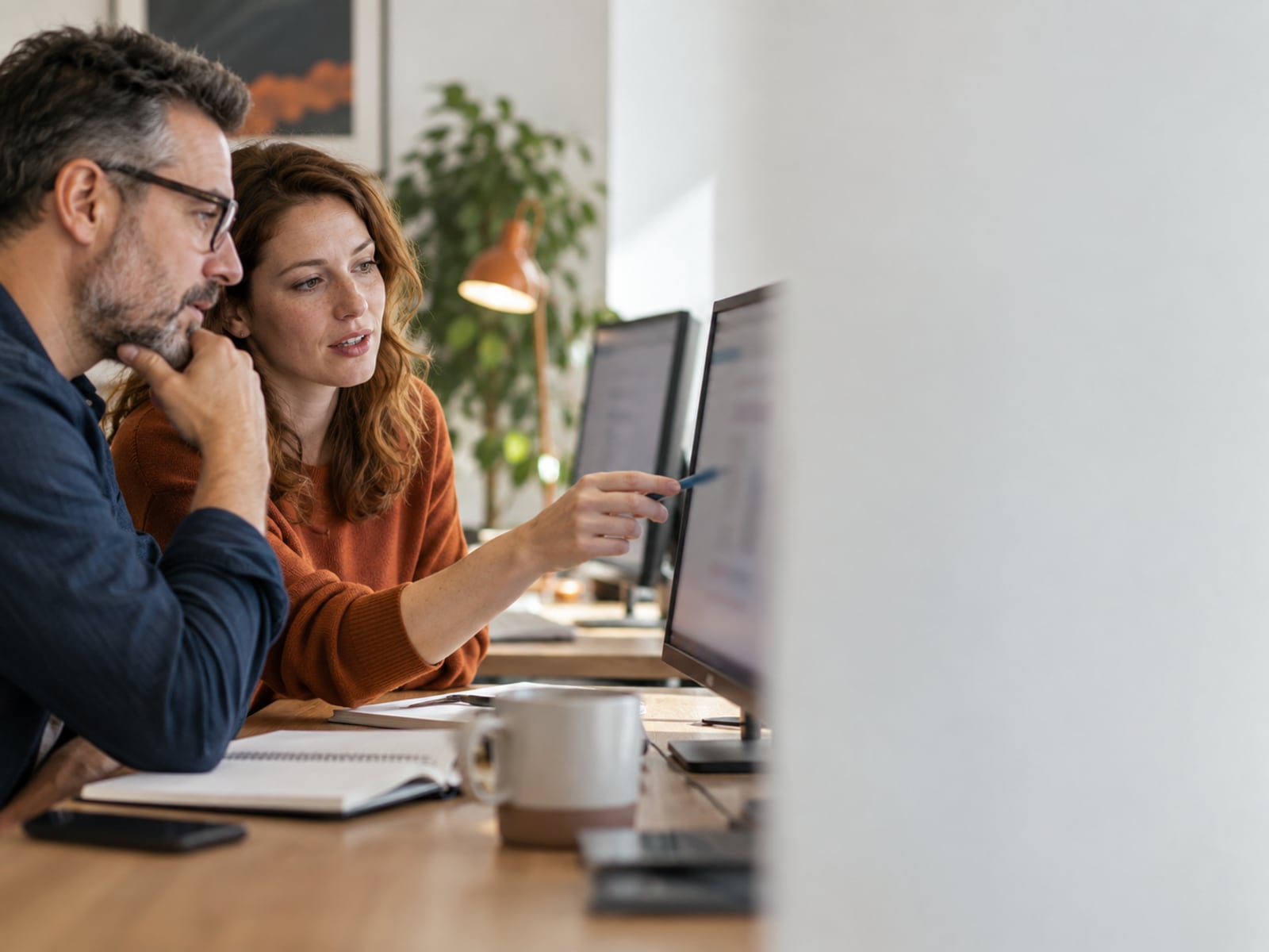 An analyst and service lead reviewing performance information.